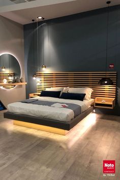 a large bed sitting in the middle of a bedroom next to a wall mounted mirror