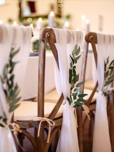 the chairs are decorated with greenery and ribbons