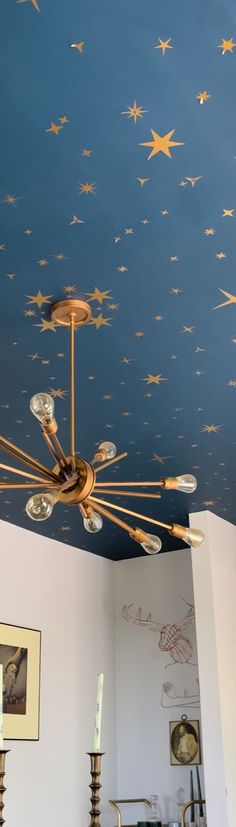 a ceiling with stars painted on it in a room that has white walls and blue ceilings