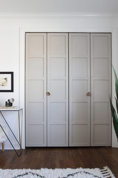 an empty room with white closets and a plant