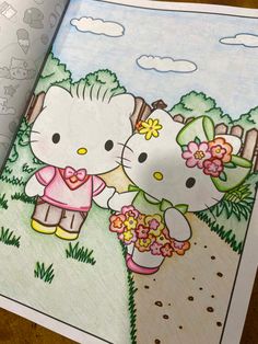 an open coloring book with two hello kitty characters on the cover and one holding flowers