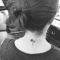 a woman with a small tattoo on her neck and behind her ear is a dandelion