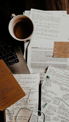 several papers with writing on them and a cup of coffee