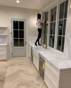 a woman standing on top of a kitchen counter