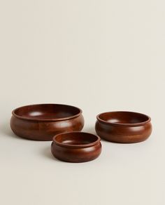 three wooden bowls sitting next to each other