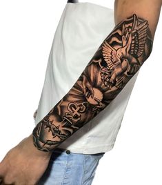 a man's arm with an eagle and cross tattoo on it