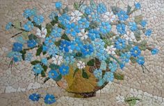 a vase filled with lots of blue flowers on top of a mosaic tile flooring