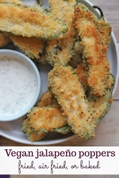 a plate with some fried food on it and a bowl of ranch dressing next to it