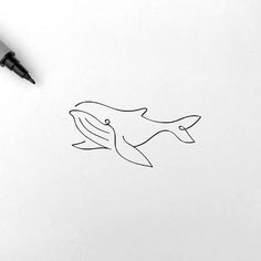 a drawing of a whale on paper with a pen