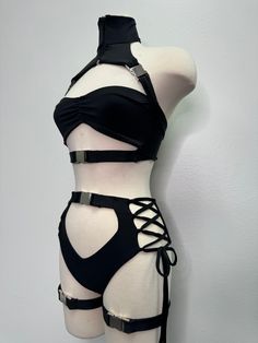 Introducing the Dakota Set, a stunning festival suit that's sure to turn heads wherever you go! This one-of-a-kind rave bodysuit features a unique design making it a true statement piece. The set is designed with leg buckles, adding a touch of edginess to the overall look. Made with high-quality materials, the Dakota Set is comfortable to wear and durable enough to withstand all your festival adventures.This festival outfit is available in XS-4X sizes, making it a versatile option for all body t Fitted Punk Harness For Alternative Fashion, Edgy Fitted Harness For Alternative Fashion, Punk Strapped Fitted Harness, Rave Party Swimwear, Black Punk Harness For Festival, Black Punk Style Festival Harness, Edgy Strapped Party Harness, Adjustable Strapped Party Harness, Edgy Strapped Harness For Parties