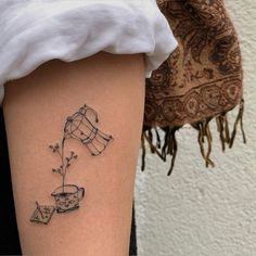 a woman's leg with a tattoo on it that has coffee cups and teacups