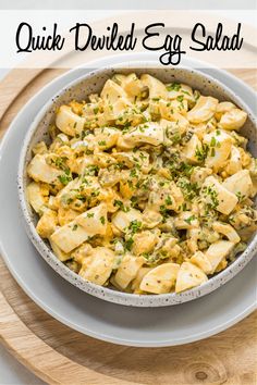 an egg salad in a bowl on top of a wooden board with the words quick boiled egg salad