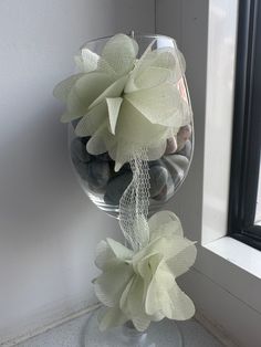 a vase filled with rocks and flowers next to a window