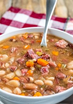 a close up of a bowl of soup on a table with a spoon in it