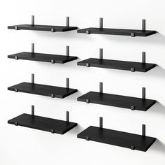 several black shelves are arranged in the shape of squares and rectangles with metal brackets on each shelf