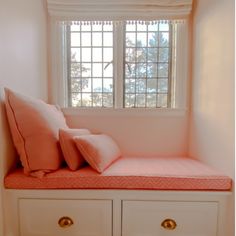 a window seat with two pillows on it