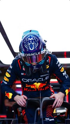 a man sitting on top of a car wearing a helmet