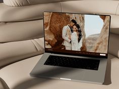 an open laptop computer sitting on top of a couch