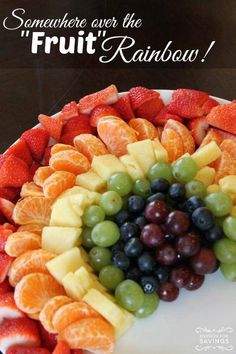 a cake with fruit arranged in the shape of a rainbow