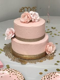 a pink and gold wedding cake with flowers on top