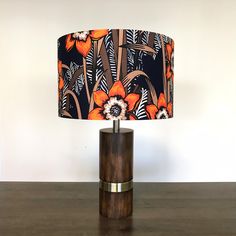 an orange flower lamp sitting on top of a wooden table