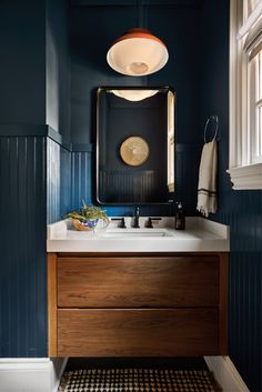 a bathroom with blue walls and wooden cabinets