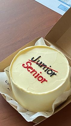 a white cake in a box with the words junior simon on it's side