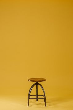 a small wooden table sitting on top of a yellow floor