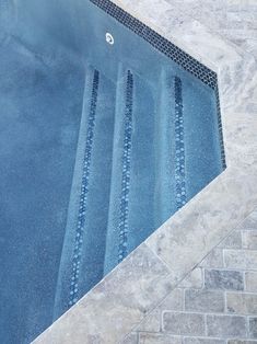 an empty swimming pool with steps leading up to the edge and water running down it