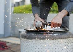 a man is using a grinder on a large metal object with sparks coming out of it