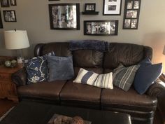 a living room filled with furniture and framed pictures on the wall above it's coffee table