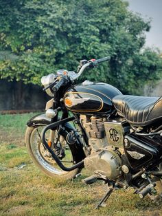 a black motorcycle parked on top of a lush green field