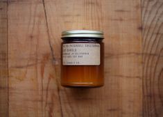 a jar of honey sitting on top of a wooden table