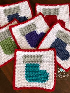 four crocheted coasters are sitting on a wooden table with the same pattern