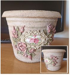 a flower pot with roses painted on the side and in front of it, sitting on a table