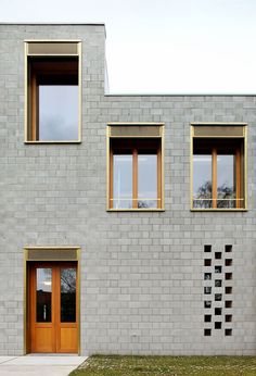 two windows on the side of a gray brick building