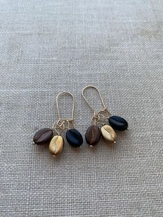 New Coffee Bean Bead Gold Filled Interchangeable Ear Wire Set. Three gorgeous Coffee options! These dainty beauties are the absolute perfect pick me up for the coffee lover. Wear them together or individually. The Classic coffee bean beads have a metallic bronze sheen that gives them a beautiful freshly roasted look.   Black coffee bean beads for when your in the mood for something simpler, yet dark and rich.   Golden coffee beans beads for when you are in the mood for that touch of gold. I have Golden Coffee, Coffee Bean Earrings, Gold Filled Earrings, Wire Wrapped Earrings, Coffee Bean, Metal Earrings, Gold Filled Jewelry, Coffee Beans, Sterling Silver Pendants