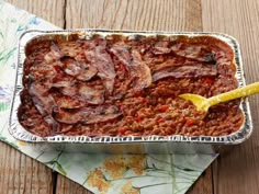 a pan filled with meat sitting on top of a wooden table