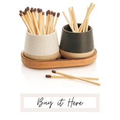 two ceramic cups with matches and one wooden stick in the bottom that says buy it here