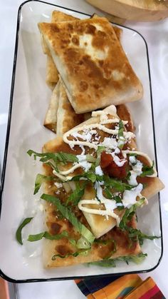 a white plate topped with two quesadillas covered in toppings