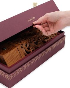 a person is opening a wooden box with the lid open