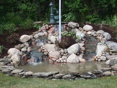 there is a small waterfall in the middle of this rock garden with lots of rocks around it