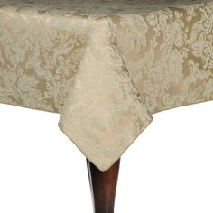 a table with a beige damask design on it and a brown wooden stand underneath the table