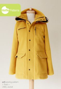 a yellow coat on a mannequin with a green sign above it that says, women's coats