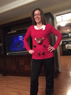 a woman standing in front of a tv wearing a red sweater and black sweatpants