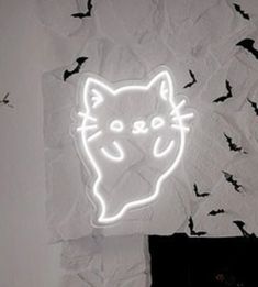 a neon sign that has a cat on it with bats in the backgroud