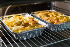 two pans filled with food cooking in an oven