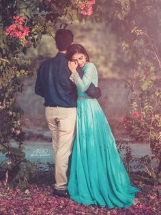 a man and woman standing under a tree