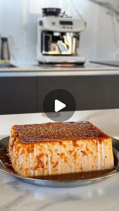 a piece of food sitting on top of a metal plate next to a coffee maker