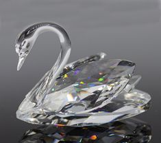 a crystal swan sculpture sitting on top of a table